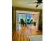 Open dining area with glass table, four chairs and French doors looking into sunroom at 201 Jacaranda Dr, Leesburg, FL 34748