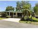 Charming home with a covered porch, driveway, and tropical landscaping at 201 Jacaranda Dr, Leesburg, FL 34748
