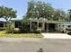 Charming single-story home featuring a covered carport, screened porch, and well-maintained landscaping at 201 Jacaranda Dr, Leesburg, FL 34748