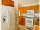 Kitchen featuring white appliances, light wood cabinets and eat-in kitchen at 201 Jacaranda Dr, Leesburg, FL 34748