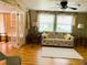 Bright living room with French doors, a comfortable floral sofa, and large windows, providing a welcoming atmosphere at 201 Jacaranda Dr, Leesburg, FL 34748