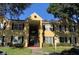 Inviting yellow two-story condo with black shutters and well-maintained landscaping at 2013 Dixie Belle Dr # 2013K, Orlando, FL 32812