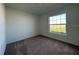 Bright bedroom features neutral carpet and a large window offering natural light and a view of the outdoors at 2117 Emma Ln, Lake Wales, FL 33898