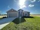 A single-Gathering home with a two-car garage, green lawn, and minimal landscaping in a sunny, open setting at 2117 Emma Ln, Lake Wales, FL 33898
