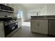 A kitchen featuring white cabinets, stainless steel appliances, granite countertops, and tile flooring at 2117 Emma Ln, Lake Wales, FL 33898