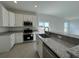 A kitchen featuring white cabinets, stainless steel appliances, granite countertops, and tile flooring at 2117 Emma Ln, Lake Wales, FL 33898