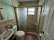 This bathroom features a glass shower with tile and a white sink and toilet at 2216 Weber St, Lakeland, FL 33801