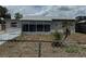 Modest single-story home with gray exterior, screen porch, and small palm tree at 2216 Weber St, Lakeland, FL 33801