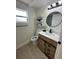 Bathroom featuring a modern vanity, decorative mirror, and a window for natural light at 2217 Azalea Ct, Lakeland, FL 33815