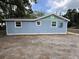 The side exterior view of a one story blue home with clean white trim at 2217 Azalea Ct, Lakeland, FL 33815
