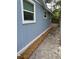 The side of the home features updated windows, vinyl siding, and mulch landscaping at 2217 Azalea Ct, Lakeland, FL 33815