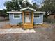Beautiful blue home with fresh landscaping and a inviting porch leading to the front door at 2217 Azalea Ct, Lakeland, FL 33815