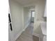 Hallway view shows light walls, trim, and flooring with a door to the exterior at 2217 Azalea Ct, Lakeland, FL 33815