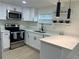 Modern kitchen boasts stainless steel appliances, white cabinetry, and quartz countertops at 2217 Azalea Ct, Lakeland, FL 33815