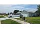 Single-story home with attached two-car garage, sidewalk, and adjacent green space at 303 Silk Oak Dr, Kissimmee, FL 34743