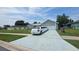 Charming home exterior featuring a long driveway with a white limousine and well-maintained landscaping at 303 Silk Oak Dr, Kissimmee, FL 34743