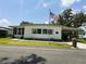 Charming single-story home featuring a covered carport, well-maintained lawn and an American flag at 313 Palo Verde Dr, Leesburg, FL 34748