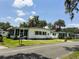 Street view of cozy single-story homes with well-kept lawns, blue sky, and an American flag at 313 Palo Verde Dr, Leesburg, FL 34748