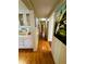 Hallway with hardwood floors leading to a bedroom with a dressing table, closet, and wood paneled walls at 313 Palo Verde Dr, Leesburg, FL 34748