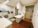 Galley kitchen featuring white appliances, wood-look flooring, and a pass-through counter at 313 Palo Verde Dr, Leesburg, FL 34748