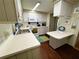 Bright kitchen with wooden cabinets, white appliances and breakfast bar at 313 Palo Verde Dr, Leesburg, FL 34748