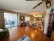 Open floor plan living room with hardwood floors, built-in shelving, and a sunroom with sliding glass doors at 313 Palo Verde Dr, Leesburg, FL 34748