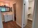 Bathroom with wood floors, modern vanity, new lights, and access to a closet at 4318 Aqua Vista Dr # K, Orlando, FL 32839