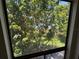 Window view with lush green trees and clear blue water in the distance at 4318 Aqua Vista Dr # K, Orlando, FL 32839