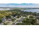 Overhead perspective of a neighborhood featuring houses, green foliage, and a glimpse of a calm lake in the background at 4514 Crichton Ln, Orlando, FL 32806
