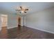 Bright bedroom featuring dark wood floors, ceiling fan, closet and adjoining bathroom at 4514 Crichton Ln, Orlando, FL 32806