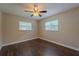 Inviting bedroom featuring dark wood floors, a ceiling fan, and natural light from two windows at 4514 Crichton Ln, Orlando, FL 32806