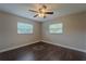 Cozy bedroom with hardwood floors, neutral walls, two windows with blinds, and a ceiling fan at 4514 Crichton Ln, Orlando, FL 32806