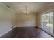 Bright dining room featuring hardwood floors, a modern chandelier, a large window, and neutral wall paint at 4514 Crichton Ln, Orlando, FL 32806