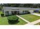 Inviting one-story home boasts a lush front lawn, neat shrubbery, and a concrete walkway to the front door at 4514 Crichton Ln, Orlando, FL 32806