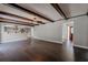 Open-concept living area with dark wood floors, beam ceilings, and adjacent kitchen at 4514 Crichton Ln, Orlando, FL 32806