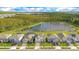 An aerial view shows multiple houses next to a pond surrounded by lush forests at 6066 Arbor Watch Loop, Orlando, FL 32829