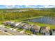An aerial view of a row of homes with manicured lawns near a peaceful pond at 6066 Arbor Watch Loop, Orlando, FL 32829