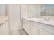 Bright bathroom features double vanity, large mirror, and shower with grey tiling at 6066 Arbor Watch Loop, Orlando, FL 32829