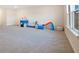 Large bonus room with neutral carpet, bright windows, and play area at 6066 Arbor Watch Loop, Orlando, FL 32829
