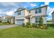 Exterior of two-story home with lush green lawn and landscaped front garden at 6066 Arbor Watch Loop, Orlando, FL 32829