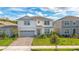 Charming two-story home with well-manicured lawn, a gray garage door, and lovely landscaping at 6066 Arbor Watch Loop, Orlando, FL 32829