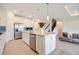 Spacious kitchen showcases stainless appliances, an island, and views into the living room and staircase at 6066 Arbor Watch Loop, Orlando, FL 32829