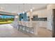 Bright open kitchen featuring white cabinetry, a center island with bar seating, and views of the backyard at 6066 Arbor Watch Loop, Orlando, FL 32829