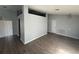 Open-concept living room with light grey walls and wood flooring throughout at 6608 Madeira Ave, Lakeland, FL 33811
