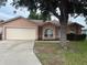 Charming single-story home features an attached two-car garage and welcoming front yard with mature tree at 6616 Shepherd Oaks St, Lakeland, FL 33811