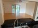 Living room view from the kitchen with bright wood-look flooring and slider to the backyard at 6616 Shepherd Oaks St, Lakeland, FL 33811