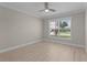 Bright bedroom featuring wood floors, a ceiling fan, and a window with views of the outdoors at 7214 Se 171St Brookhaven Pl, The Villages, FL 32162