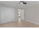 Bedroom with wood floors, a ceiling fan, and a closet with white doors at 7214 Se 171St Brookhaven Pl, The Villages, FL 32162