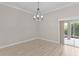 Dining Room boasts modern chandelier, neutral paint, crown molding and access to the lanai at 7214 Se 171St Brookhaven Pl, The Villages, FL 32162