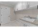 Laundry room with white cabinets, a sink, and tile floors at 7214 Se 171St Brookhaven Pl, The Villages, FL 32162